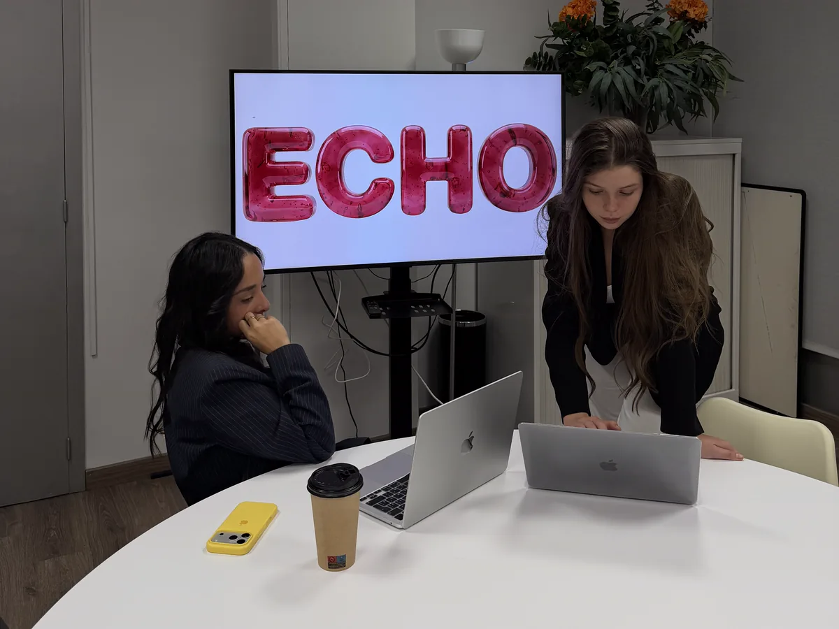 The ECHO Barcelona partners working on their laptops in front of a screen showing the ECHO logo